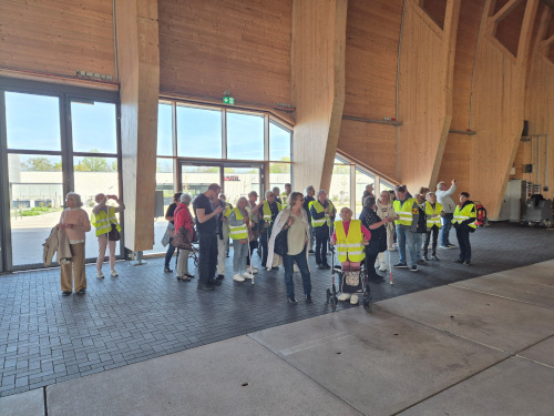 Gruppe von Menschen in einer großen Halle aus Holz