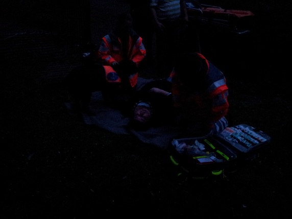 Die Blinde Maria St. Mont liegt mit ihrem Hund auf dem Boden, zwei Retter helfen